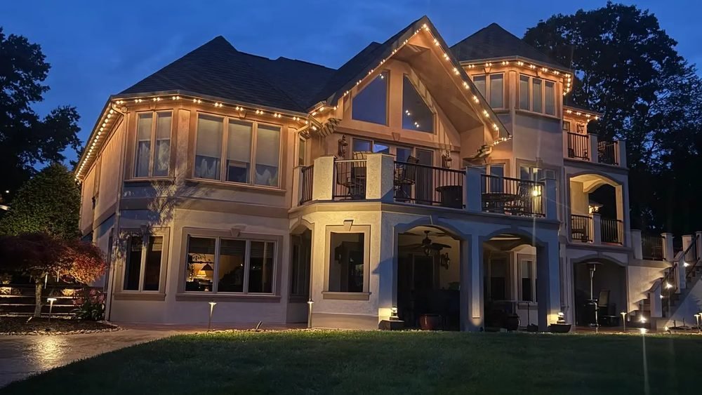 Bright Home Lights permanent track lighting running along a roofline at dusk