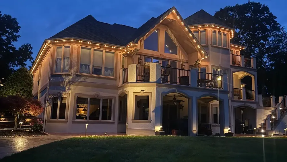 Bright Home Lights permanent track lighting running along a roofline at dusk
