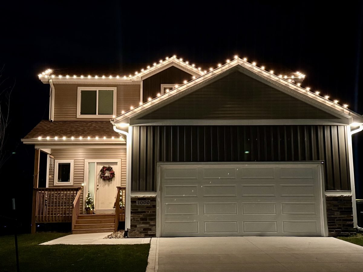 Warm white C9 bulbs spaced evenly along the gutter line and front peak of a home at dusk